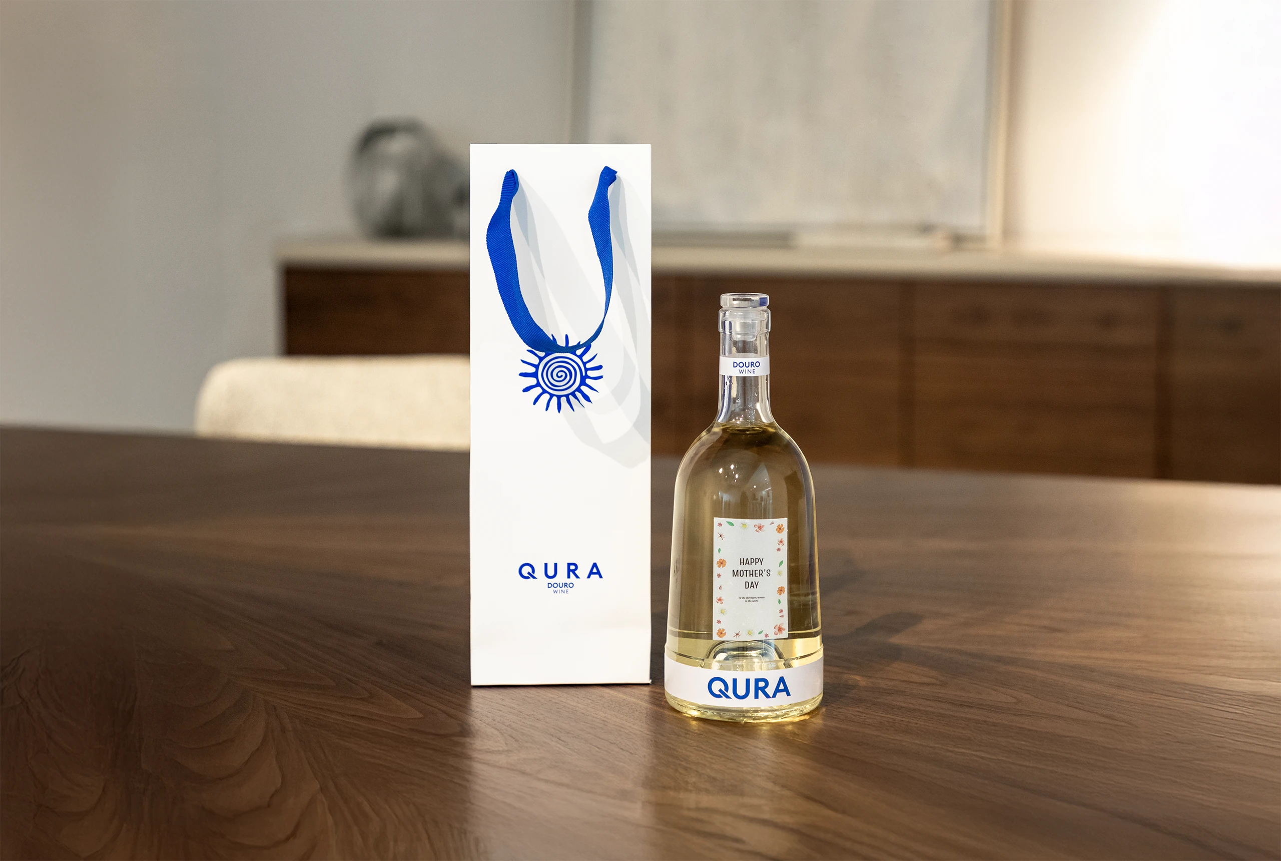 Imagem de garrafa de vinho com design personalizado, colocada sobre mesa de madeira