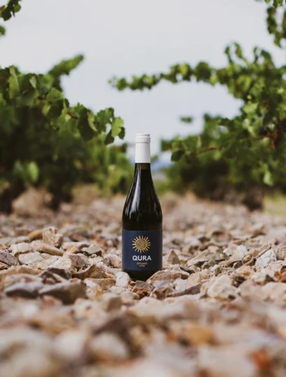 Garrafa de vinho tinto HALF QURA RED entre pedras e vinhas no Douro